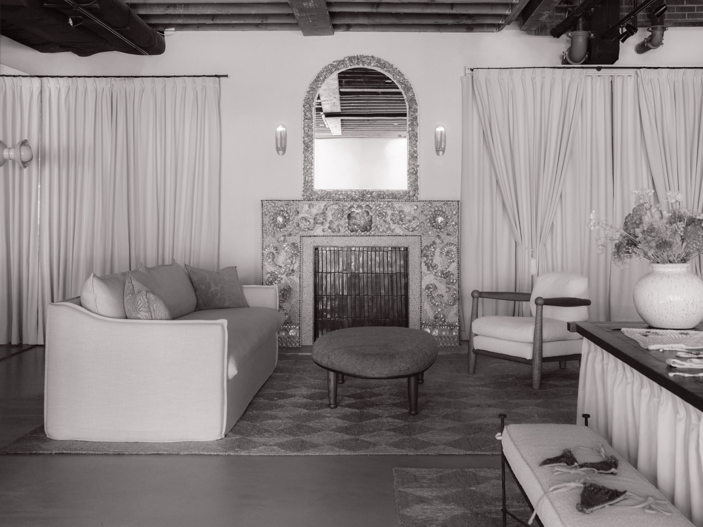 Monochrome interior with Orb wall sconces beside an ornate mirror